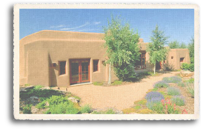 An adobe home features a xeriscape landscaping to conserve water use in the high desert of New Mexico.